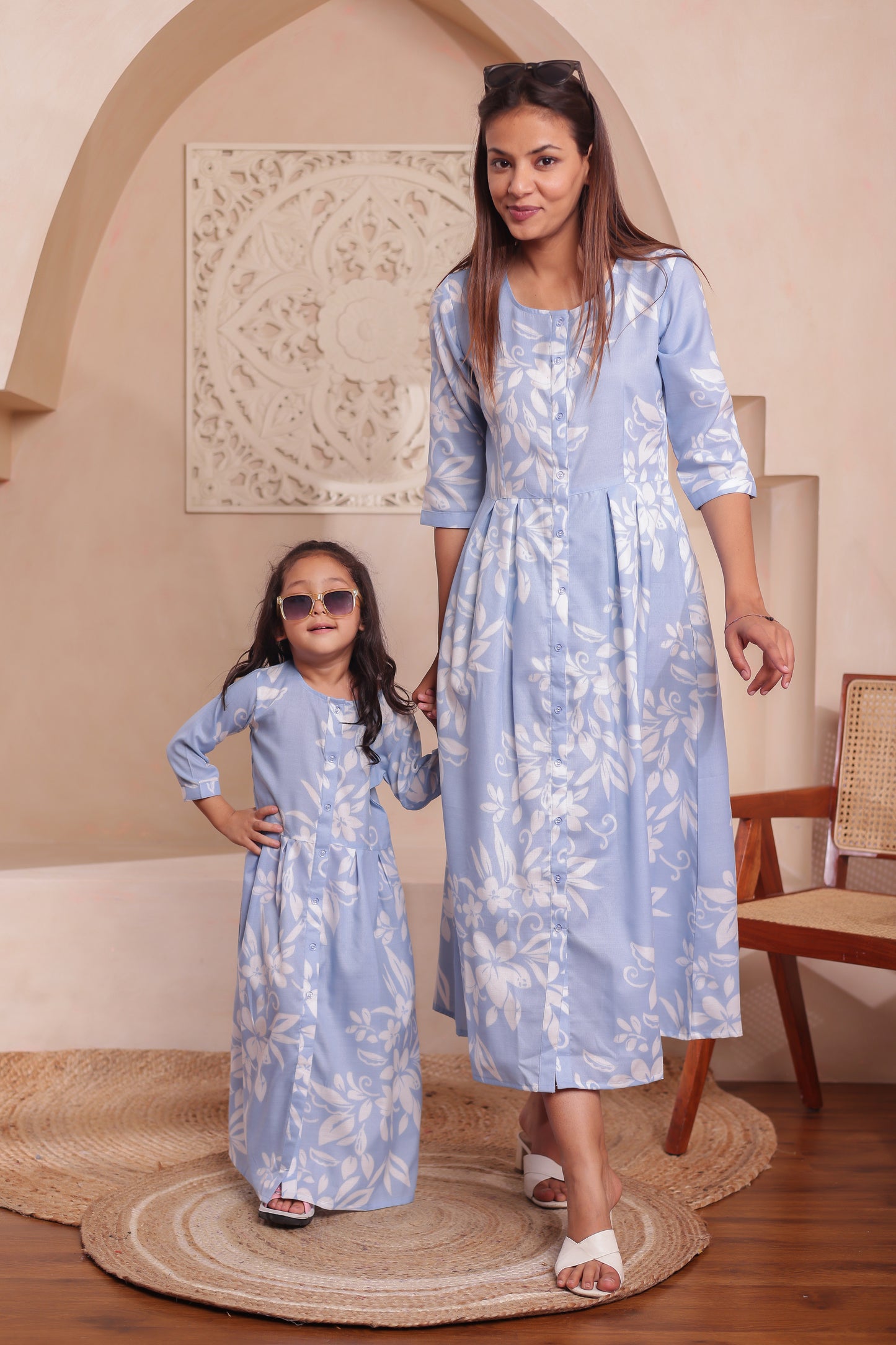 Matching blue floral print outfits for mother and daughter — mom in a soft cotton maxi dress and daughter in a flared cotton dress. Perfect for twinning at events and casual outings.