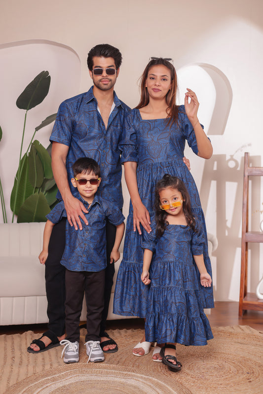 Family combo in soft denim outfits – father in denim shirt, mother in long denim dress, son in denim shirt, and daughter in long denim dress. Perfect for stylish twinning.
