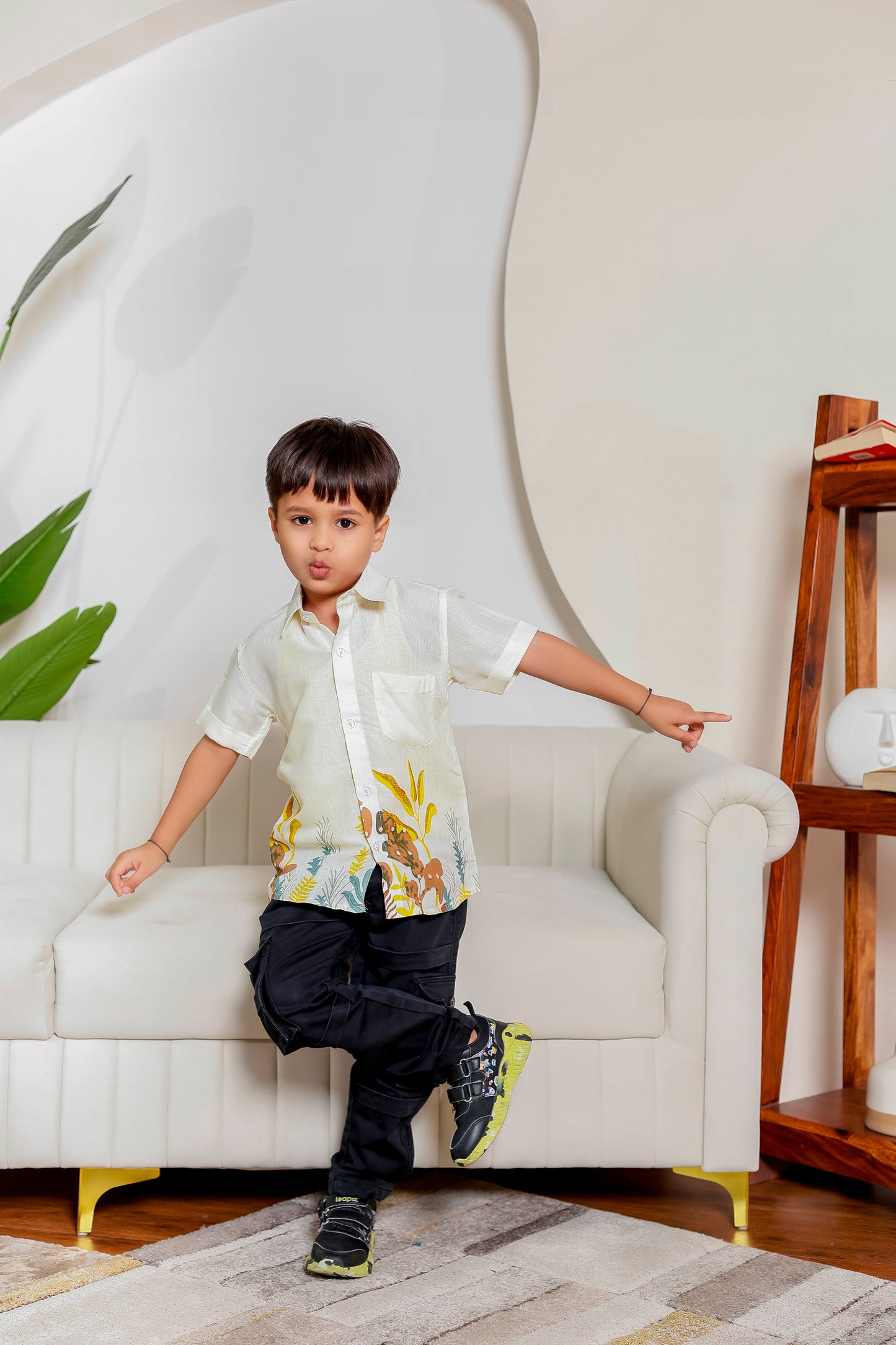 Boy in Family Safari Vibes leaf-printed cotton shirt ā great for matching family dress sets and casual outings.