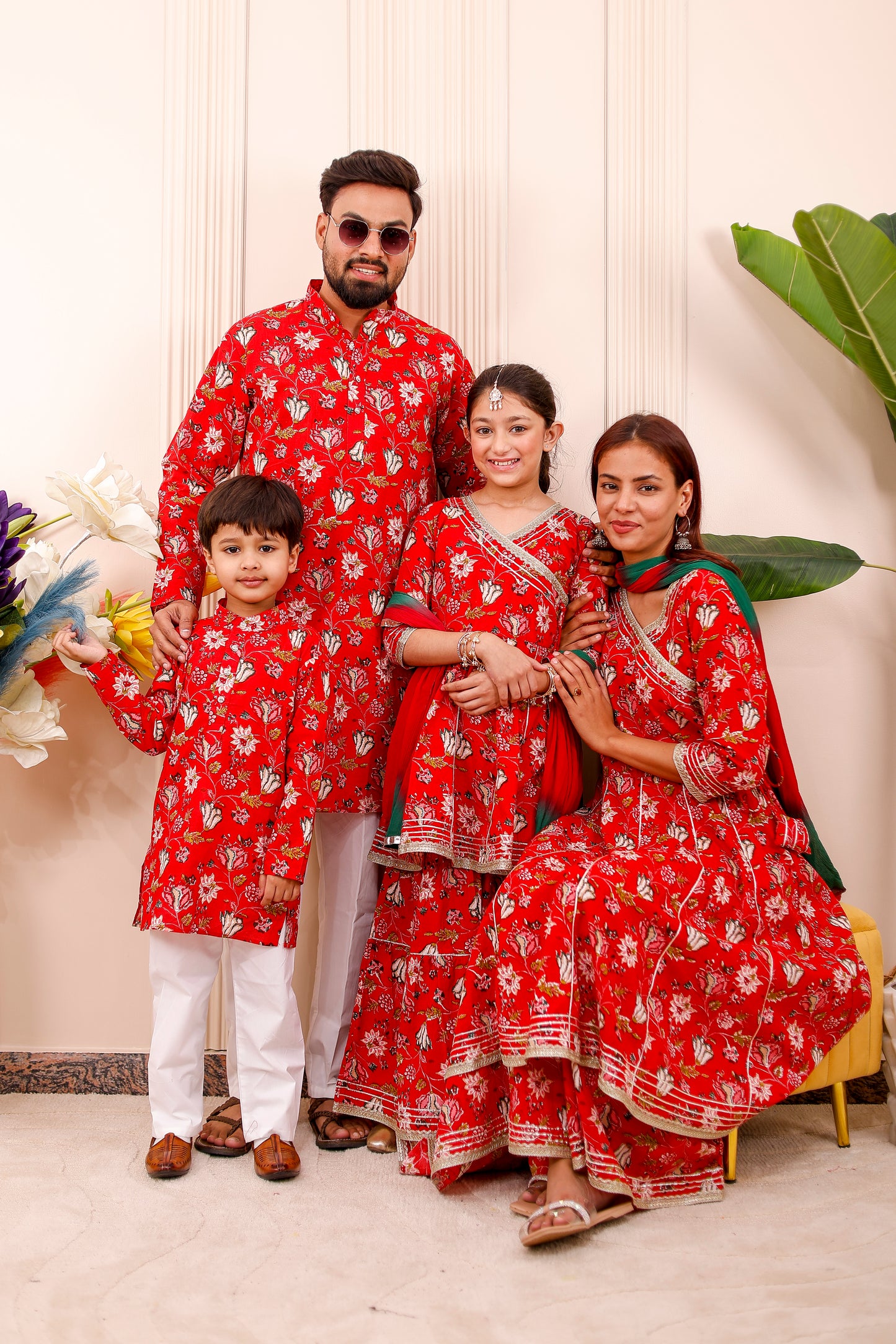 Red floral family matching outfits with coordinated designs for mom, dad, and kids, perfect for festivals, weddings, and photoshoots